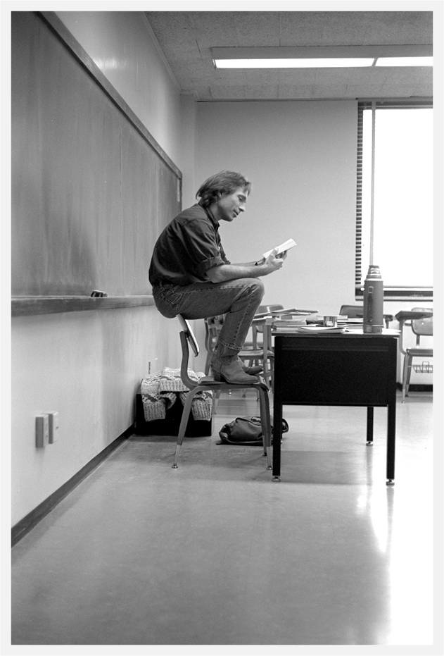 a teacher at the front of a class in black and white