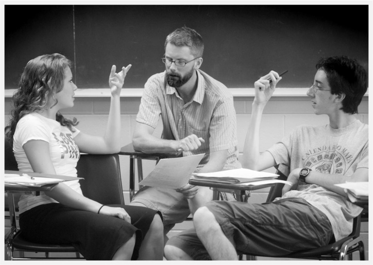 black and white photo of a teacher with two students