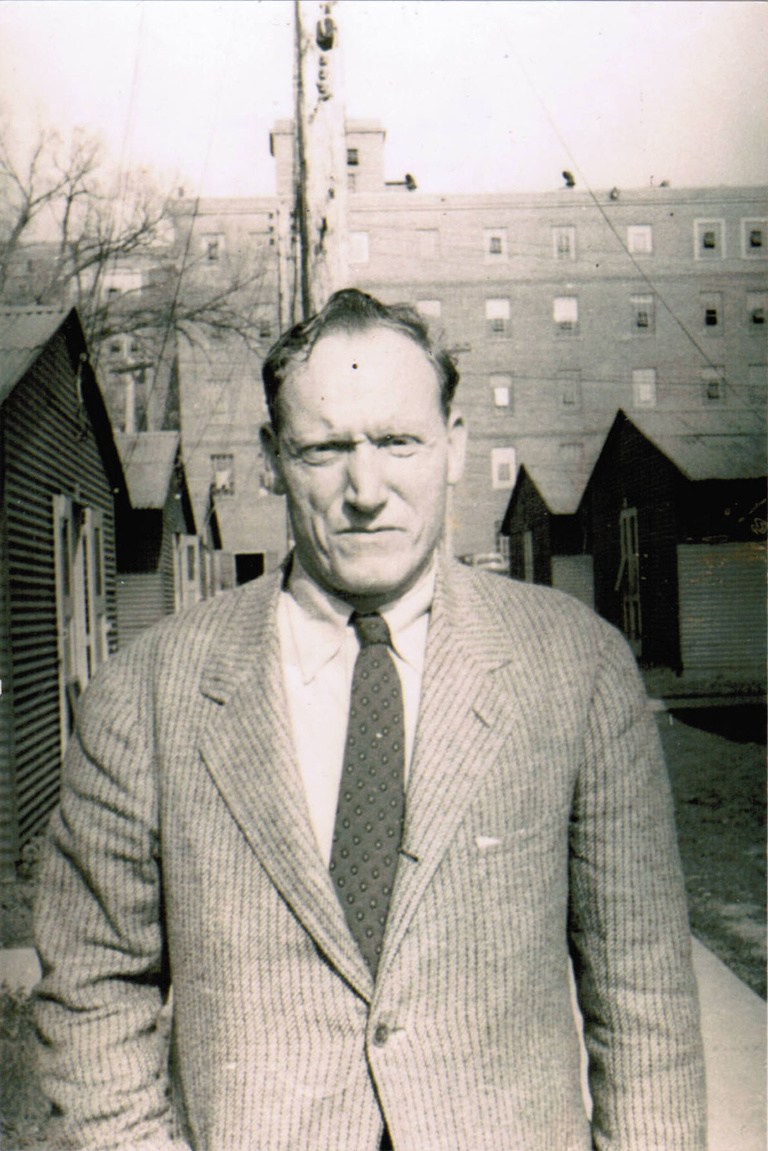 an old photo of a man in front of buildings