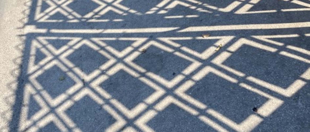 shadow of a fence on the pavement