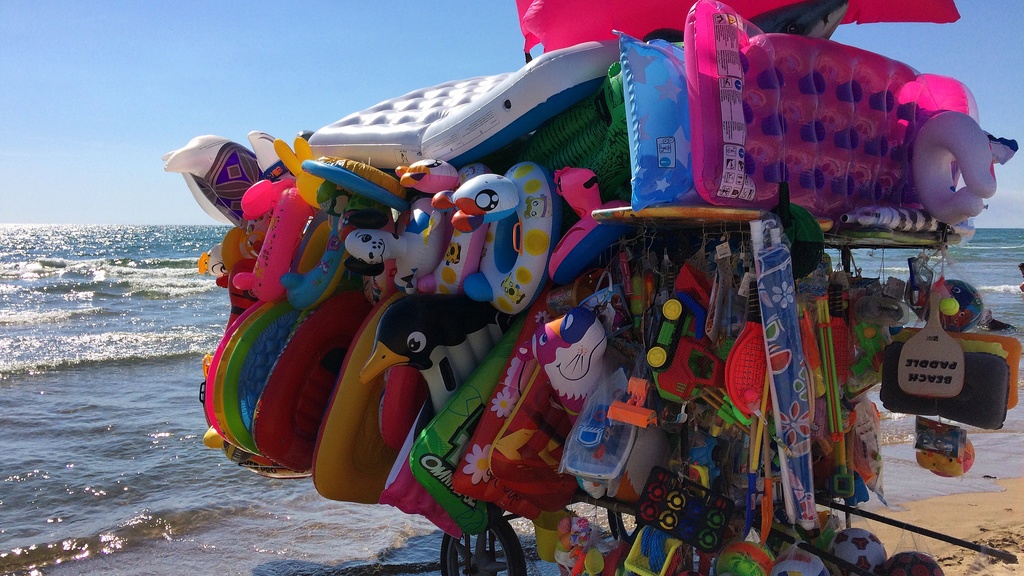Photo of a beach bike selling beach floats along the shoreline.